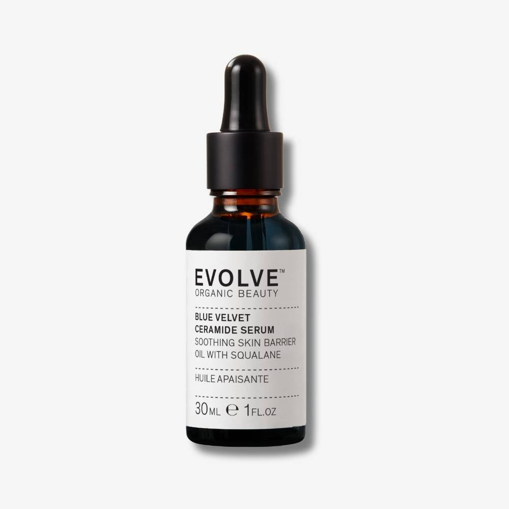 Evolve Organic Beauty Blue Velvet Ceramide Serum in brown glass bottle with black oil pipette lid on off white background with shadow behind