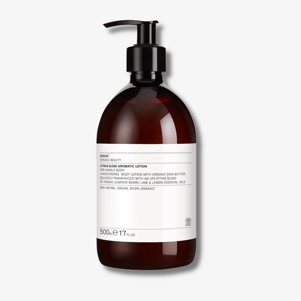 Evolve Organic Beauty citrus blend aromatic lotion in brown bottle with black pump on off white background with shadow behind