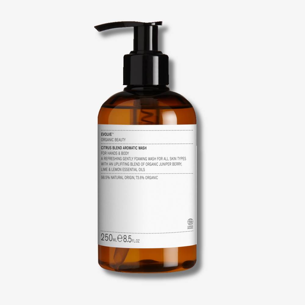 Evolve Organic Beauty Citrus Blend Aromatic Wash in brown bottle with black pump on off white background with shadow behind