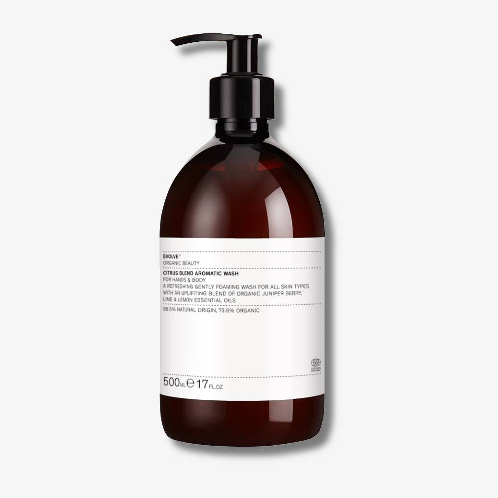 Evolve Organic Beauty citrus blend aromatic wash in brown bottle with black pump on off white background with shadow behind