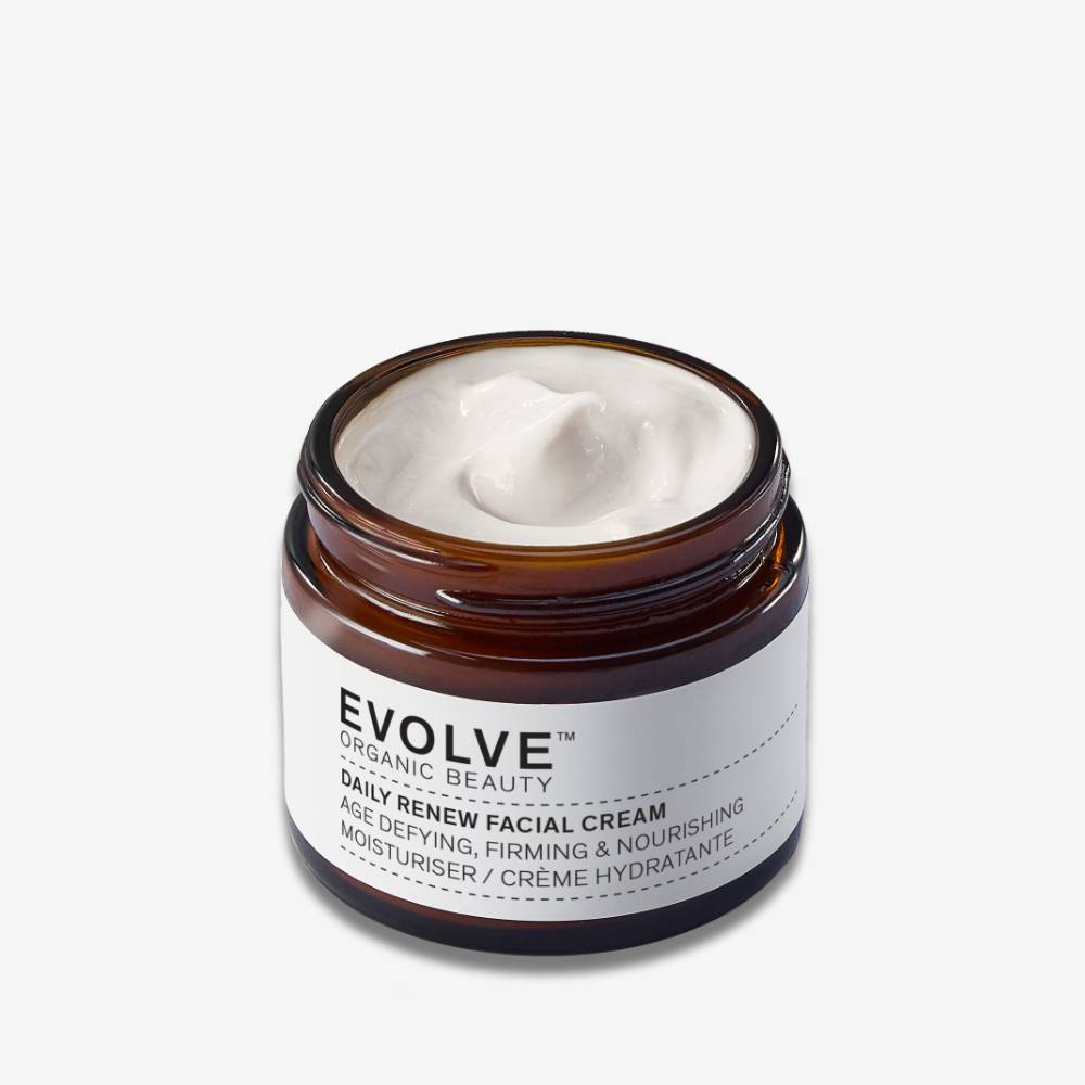 An open amber glass jar image of Evolve Organic Beauty Daily Renew Facial Cream on an off white background with shadow behind