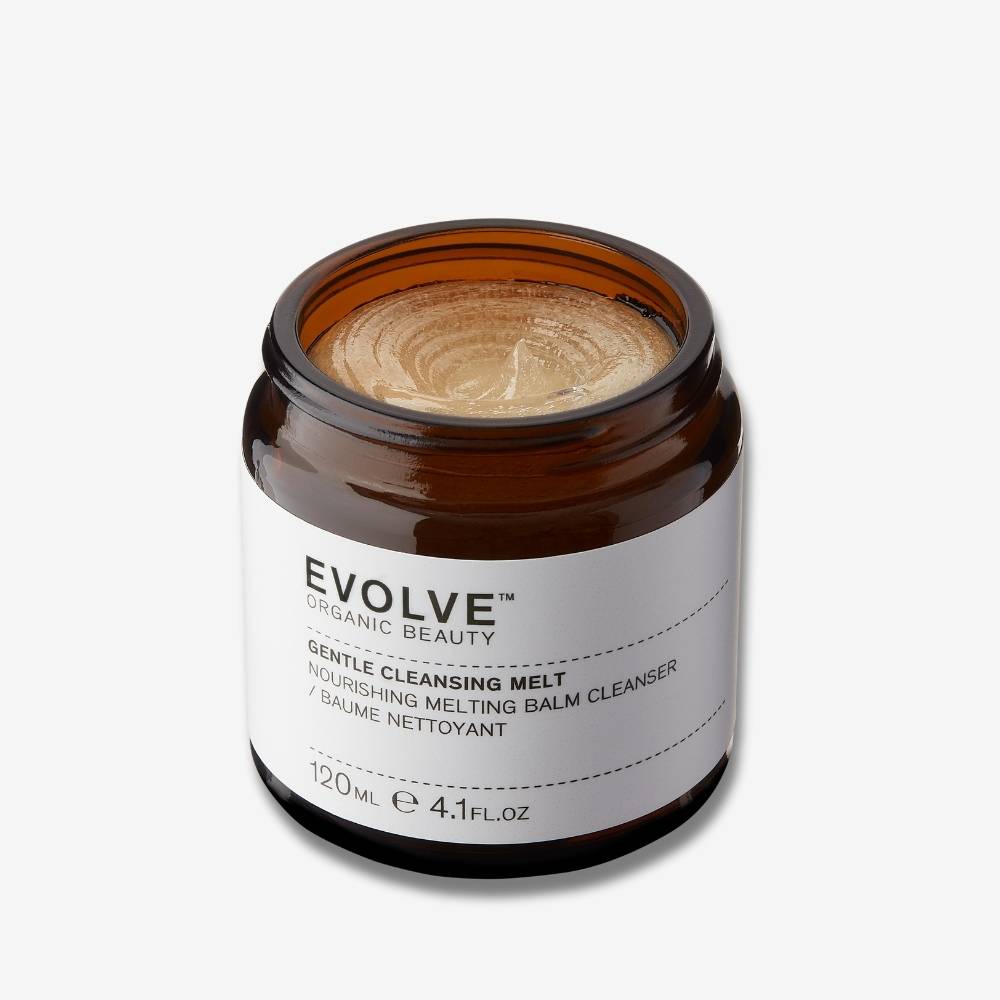 Evolve Organic Beauty Gentle Cleansing Melt in brown open jar showing the texture of the melt inside on off white background with shadow behind