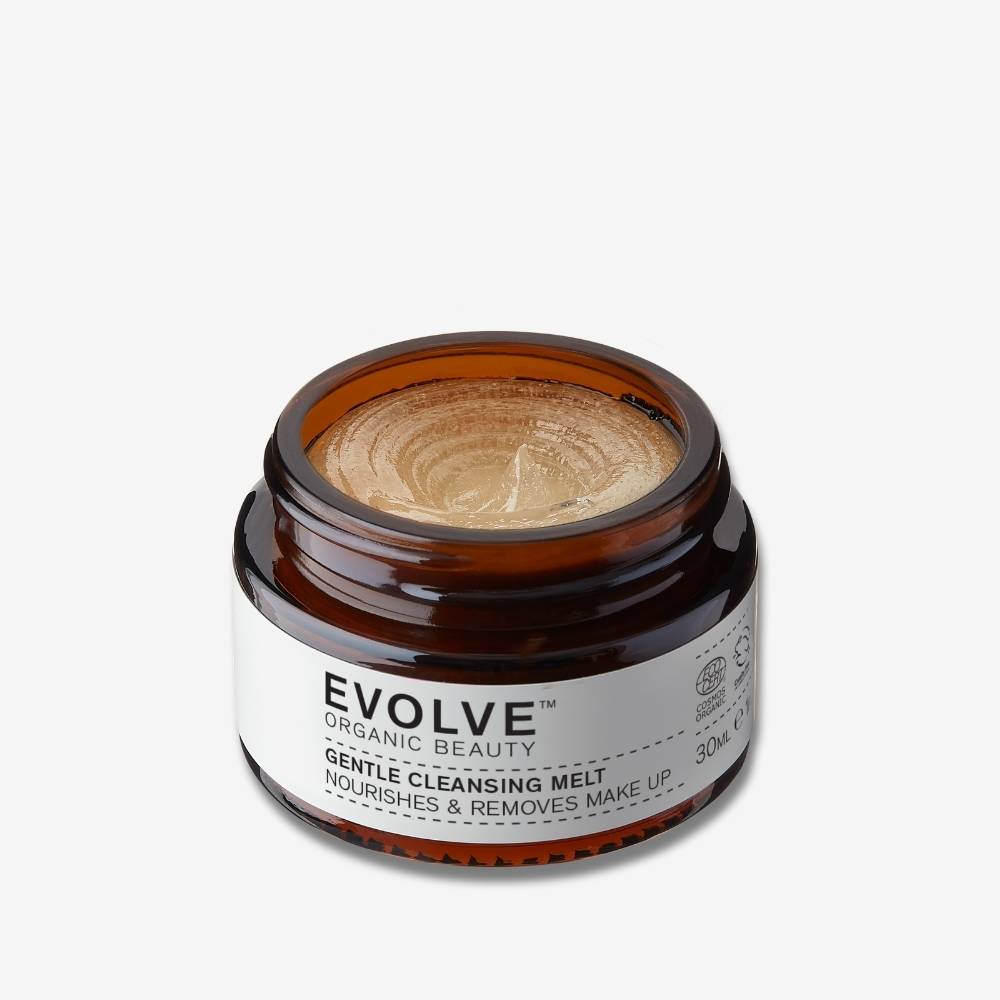Evolve Organic Beauty Gentle Cleansing Melt in a travel size brown jar opened showing its balmy texture on off white background with shadow beind