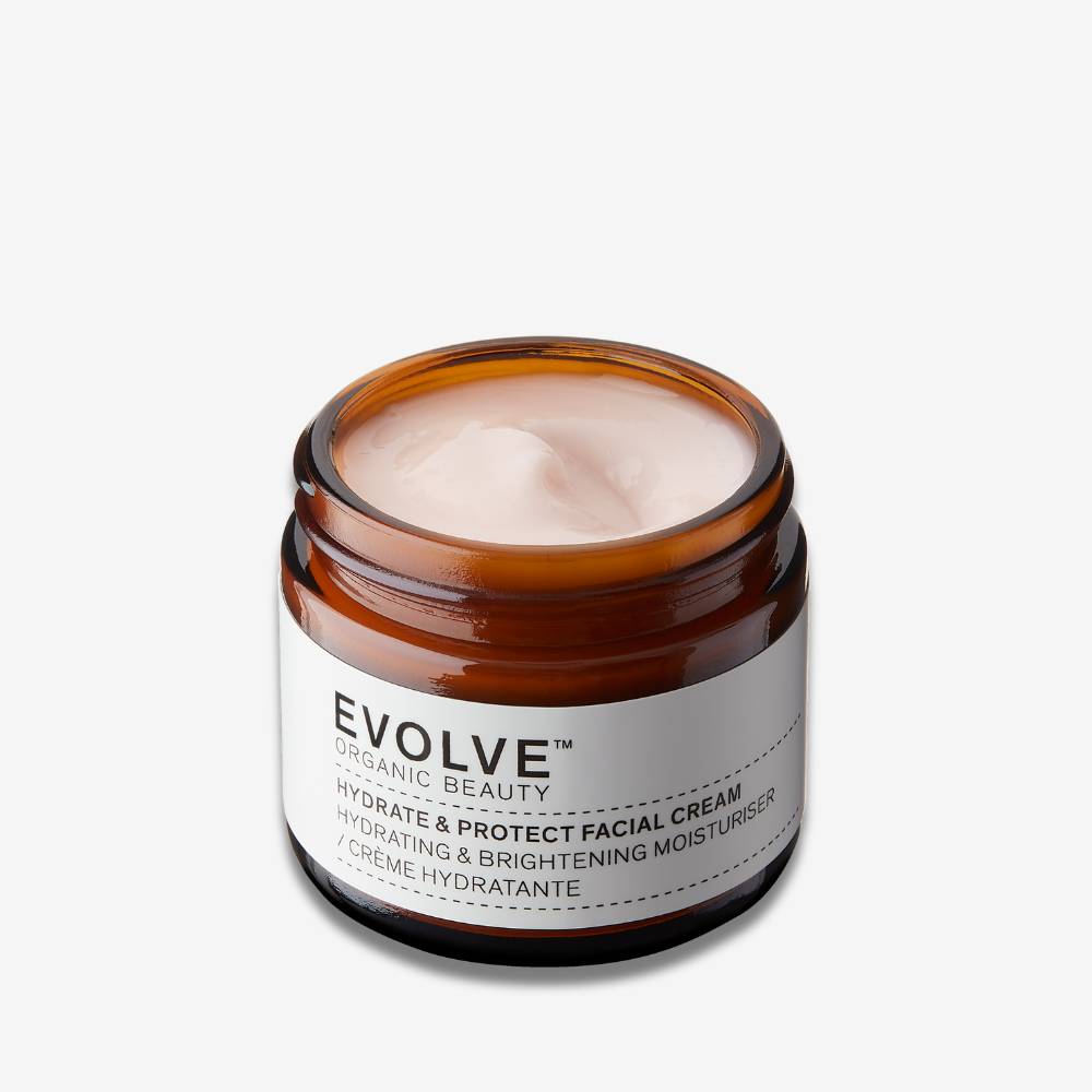 Evolve Organic Beauty Hydrate & Protect Facial Cream in brown glass jar on an off white background with shadow behind