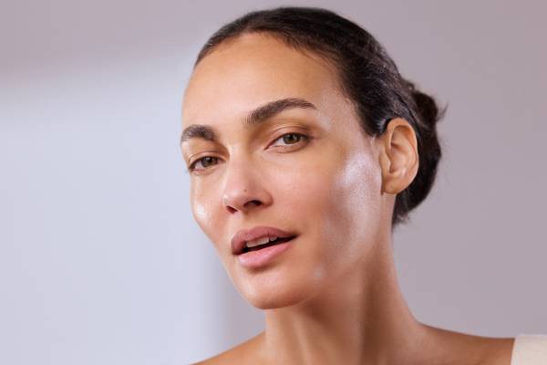 skincare model looking into camera with glowing skin