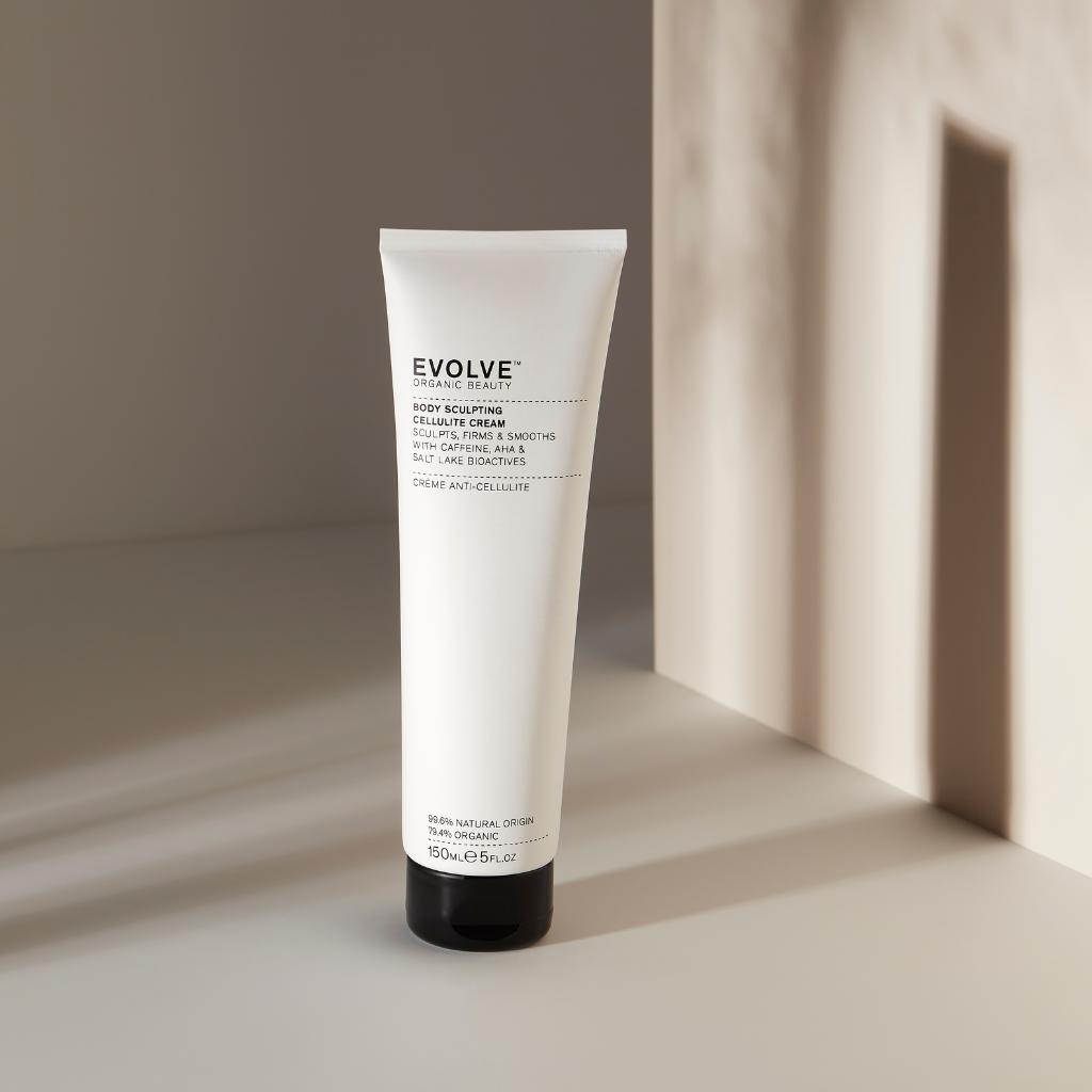 white tube of scultping cellulite cream on a beige backgroud with shadows