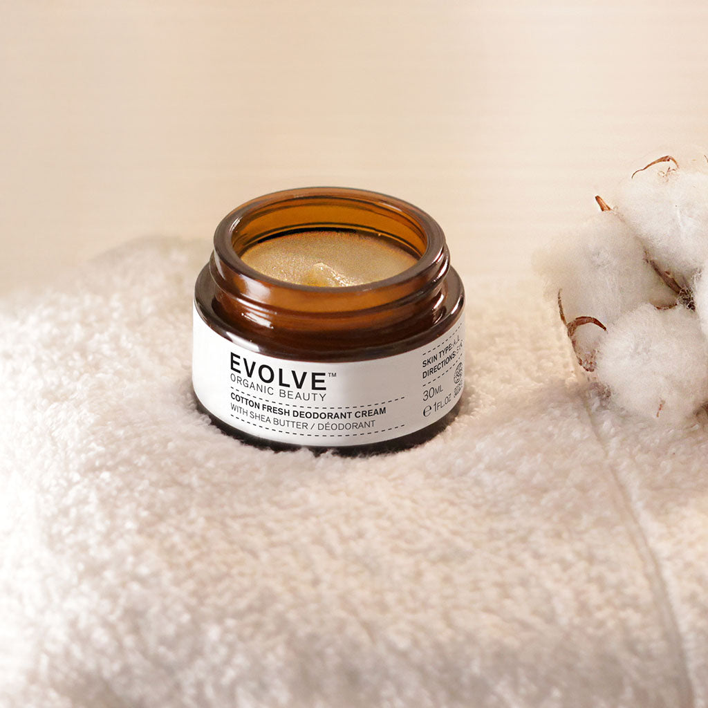 Open jar of Cotton Fresh Deodorant on a white towel with a small cotton flower to the right hand side