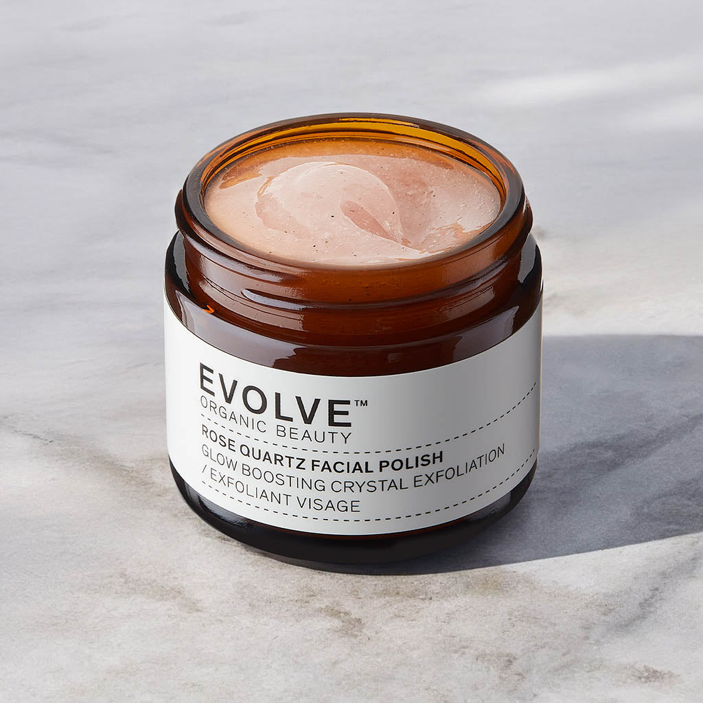 open jar of rose quartz facial polish with pretty pink texture on grey marble background