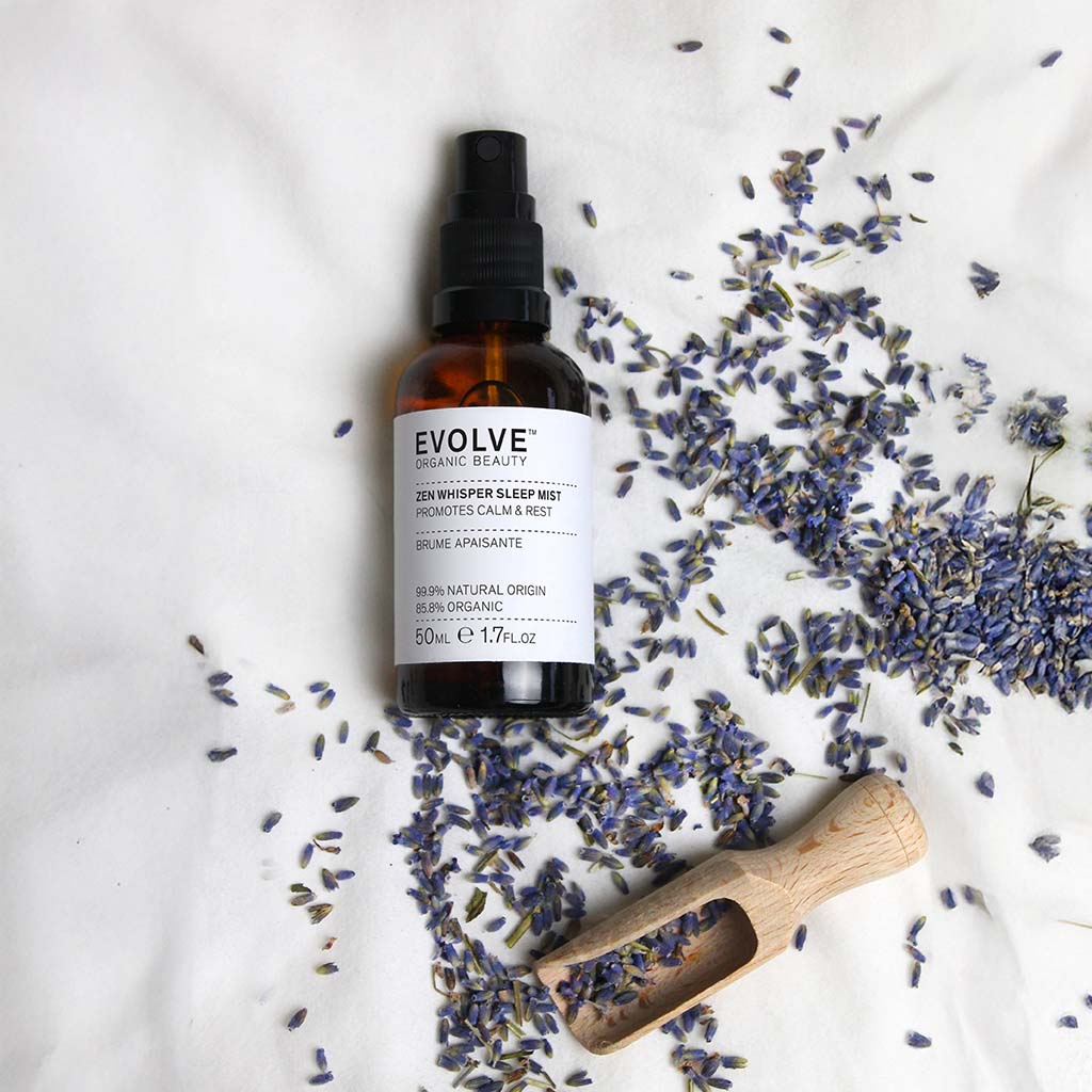Zen Whisper Sleep Mist Evolve organic beauty on soft textile with lavander scattered around