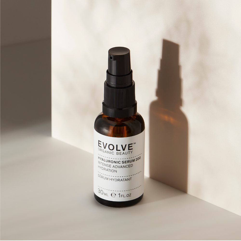 Hyaluronic Serum 200 on a natural stone surface with a shadow of the amber bottle reflecting on the wall behind