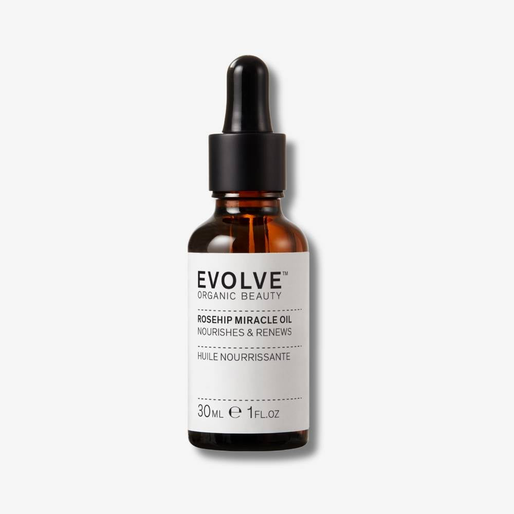 Evolve Organic Beauty Rosehip Miracle Oil in brown glass bottle with pipette on off white background with shadow behind