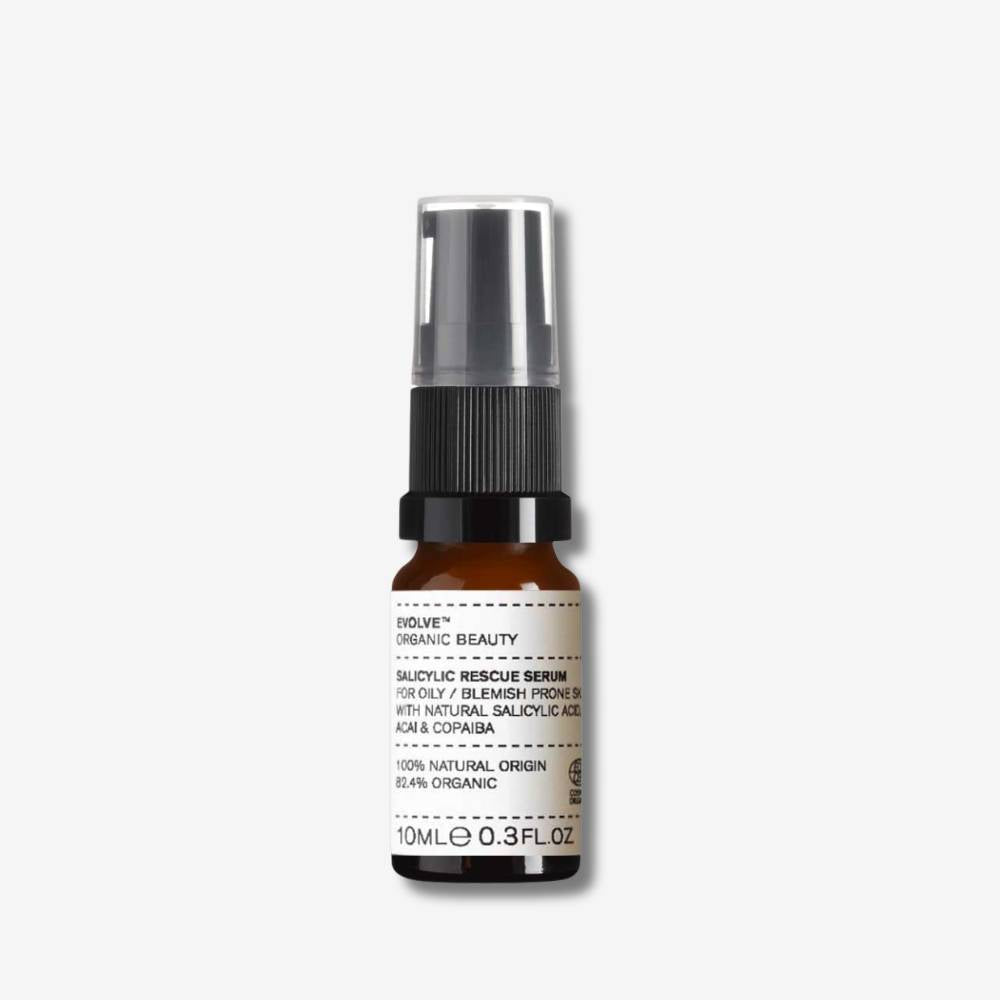 Evolve Organic Beauty Salicylic Rescue Serum in brown glass bottle with black pump lid on off white background with shadow behind