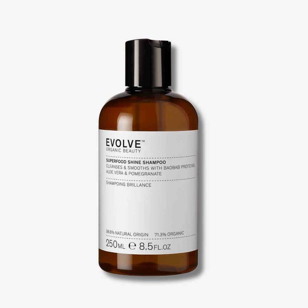 Evolve Organic Beauty Superfood Shine Shampoo brown bottle with black disc cap lid on off-white background with shadow behind