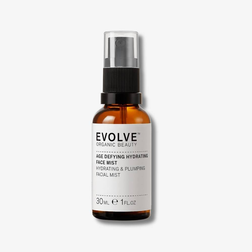 Evolve Organic Beauty Age Defying Hydrating Face Mist in brown glass bottle with black mist lid on off white background with shadow behind