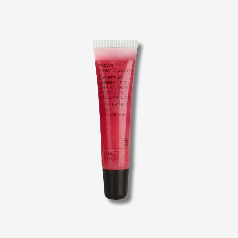 A tube of glossy lip oil with a pink tint and product information text on it.