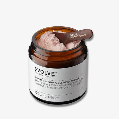 packshot of an open jar of enzyme + vitamin c powder cleanser with a small wooden spatula inside on off white background with shadow