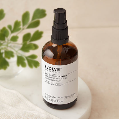 bottle of daily detox facial wash on top of marble coaster with greenery on the side 