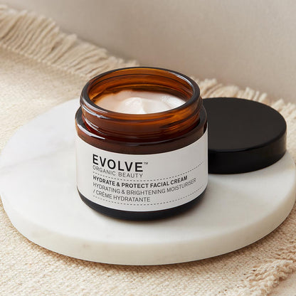Open jar of Hydrate &amp; Protect Facial Cream on a marble coaster, on top of a textured blanket