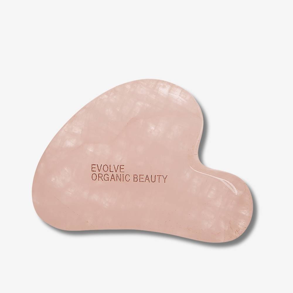 Evolve Organic Beauty Rose Quartz Gua Sha on off-white background with shadow behind