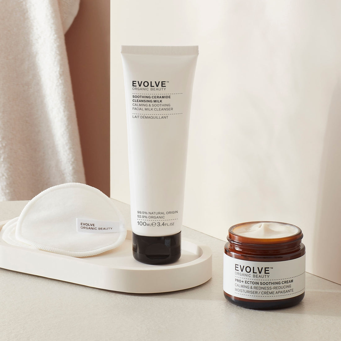 sensitive skin rescue duo bundle including soothing ceramide cleansing milk in sugarcane tube and pro+ ectoin soothing cream in brown glass jar with black lid in a bathroom setting with towel in the backgrounds products on a marble coaster and reusable bamboo pads