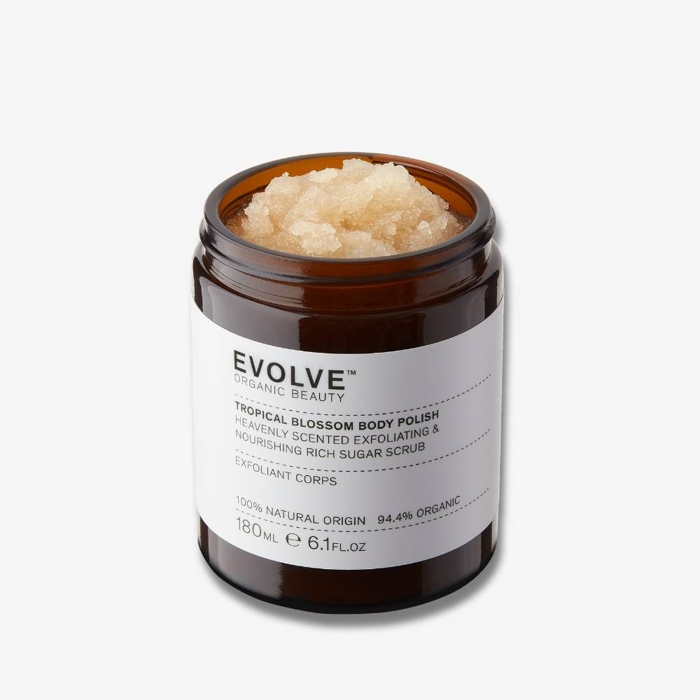 Evolve Organic Beauty tropical blossom body polish in brown glass jar with scrub texture on off white background with shadow behind
